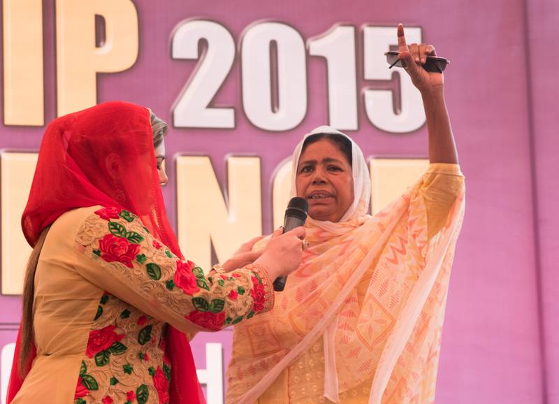 A woman testifying on stage that her eyes were healed